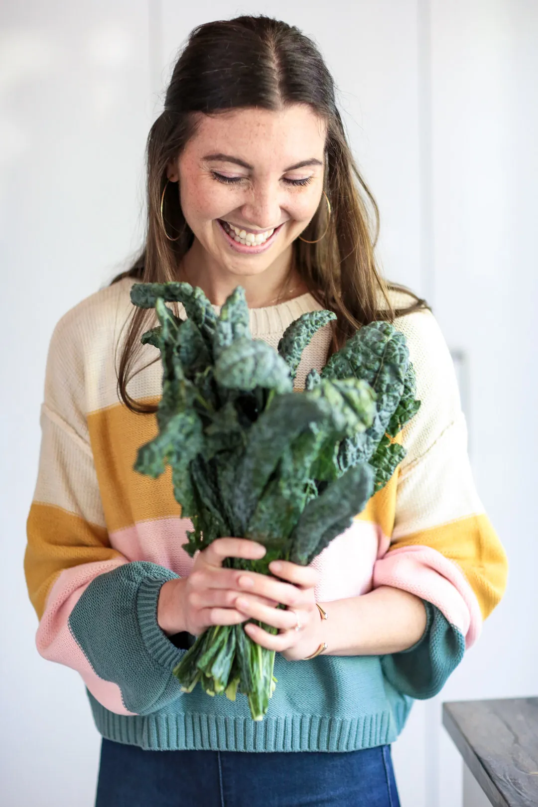 Nutrisense customer named Charlotte Laguardia standing upright with her smiley face holding a plant with both hands.