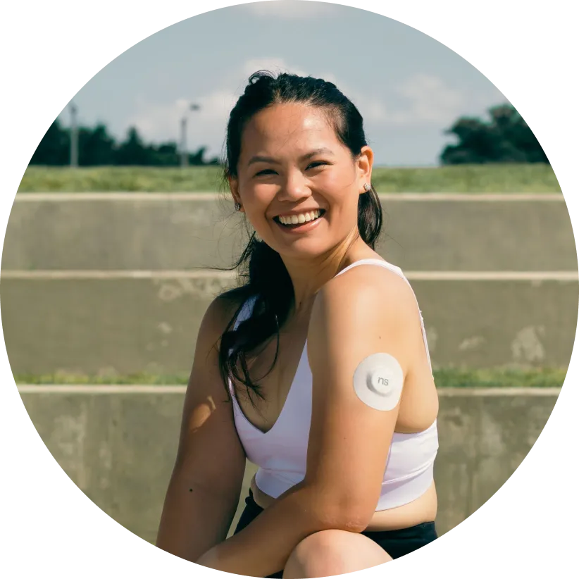 A smiley Nutrisense member wearing cgm sensor on her left upper hand.