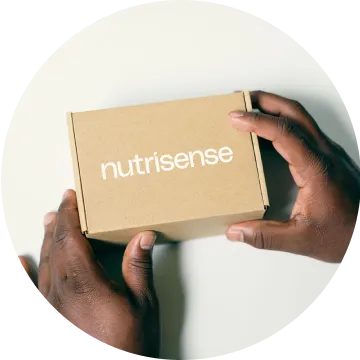 Male hands holding Nutrisense package box found at nutrisense.io