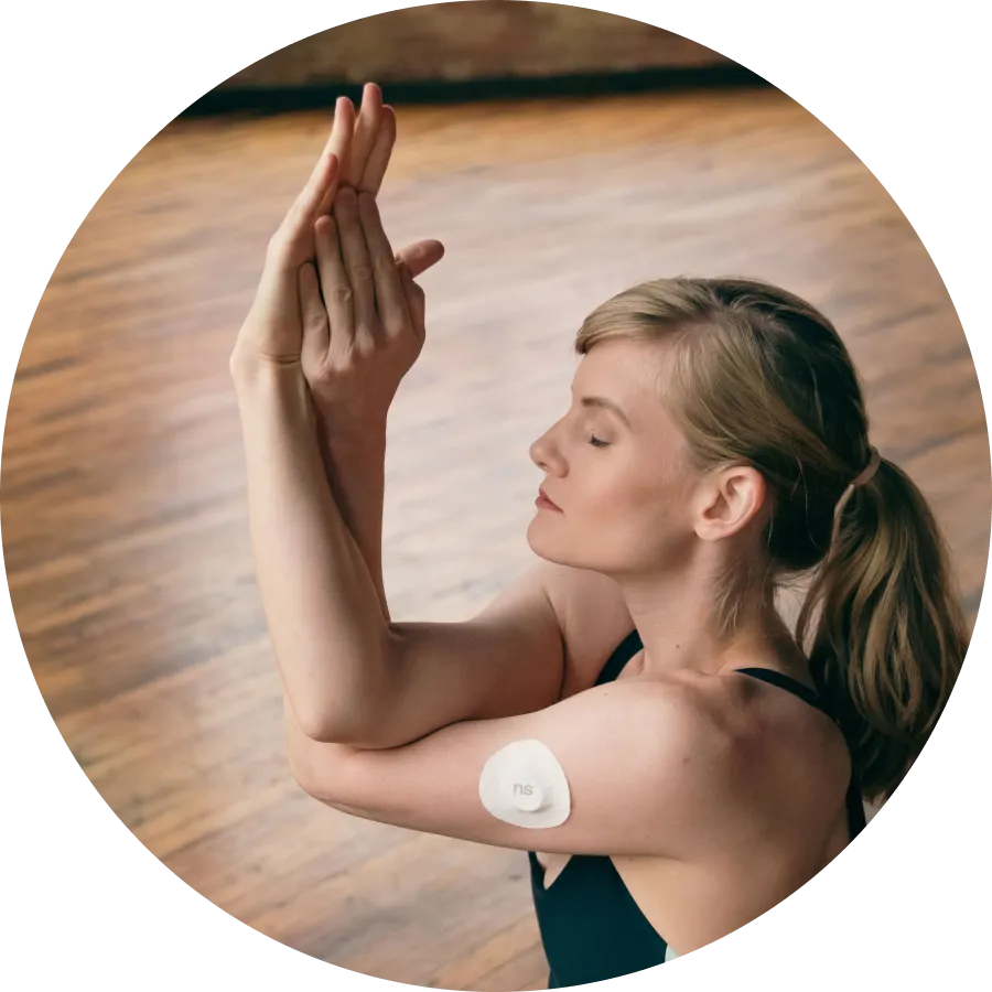 A woman practicing hormonal balance exercises with both hands wearing Nutrisense cgm sensor on her upper left hand.