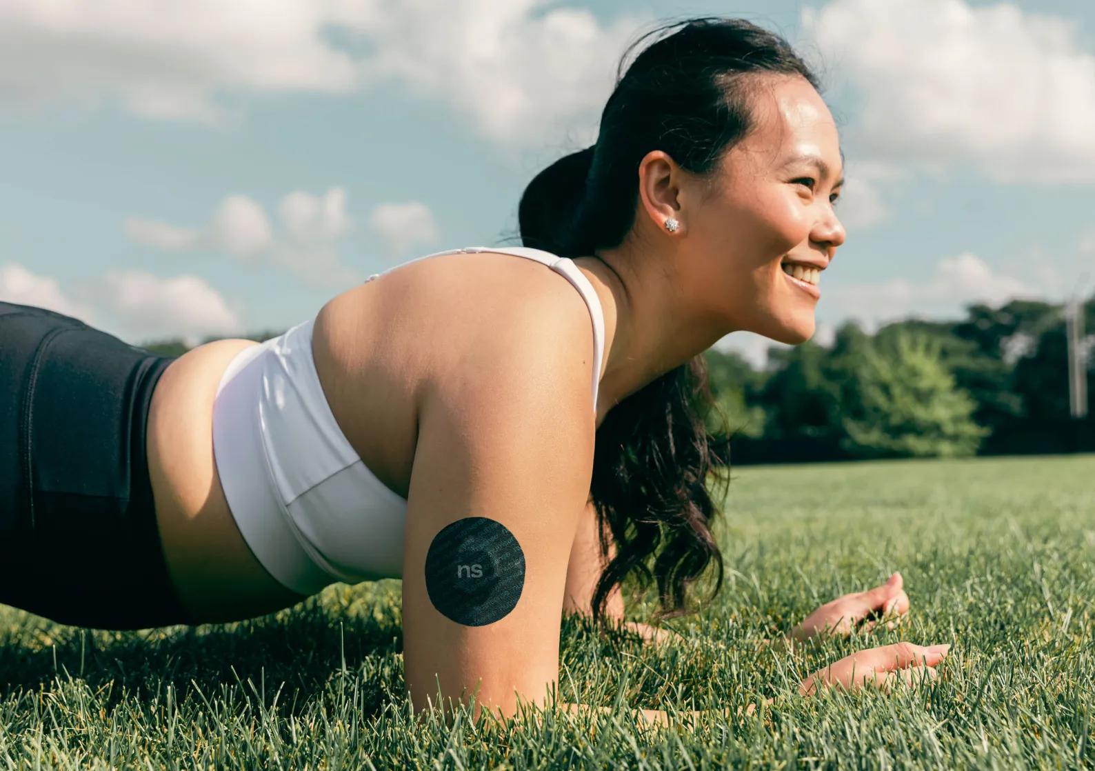 A Nutrisense member smiling while practicing plunk with her CGM sensor on her right upper hand