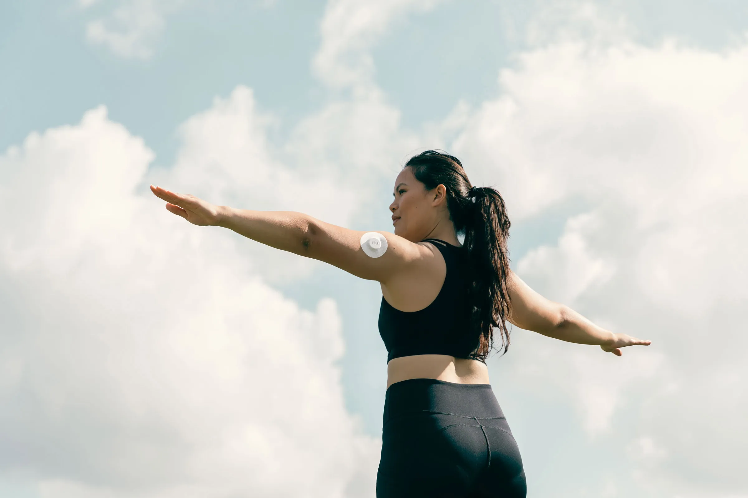 Woman doing yoga outside with Nutrisense CGM 