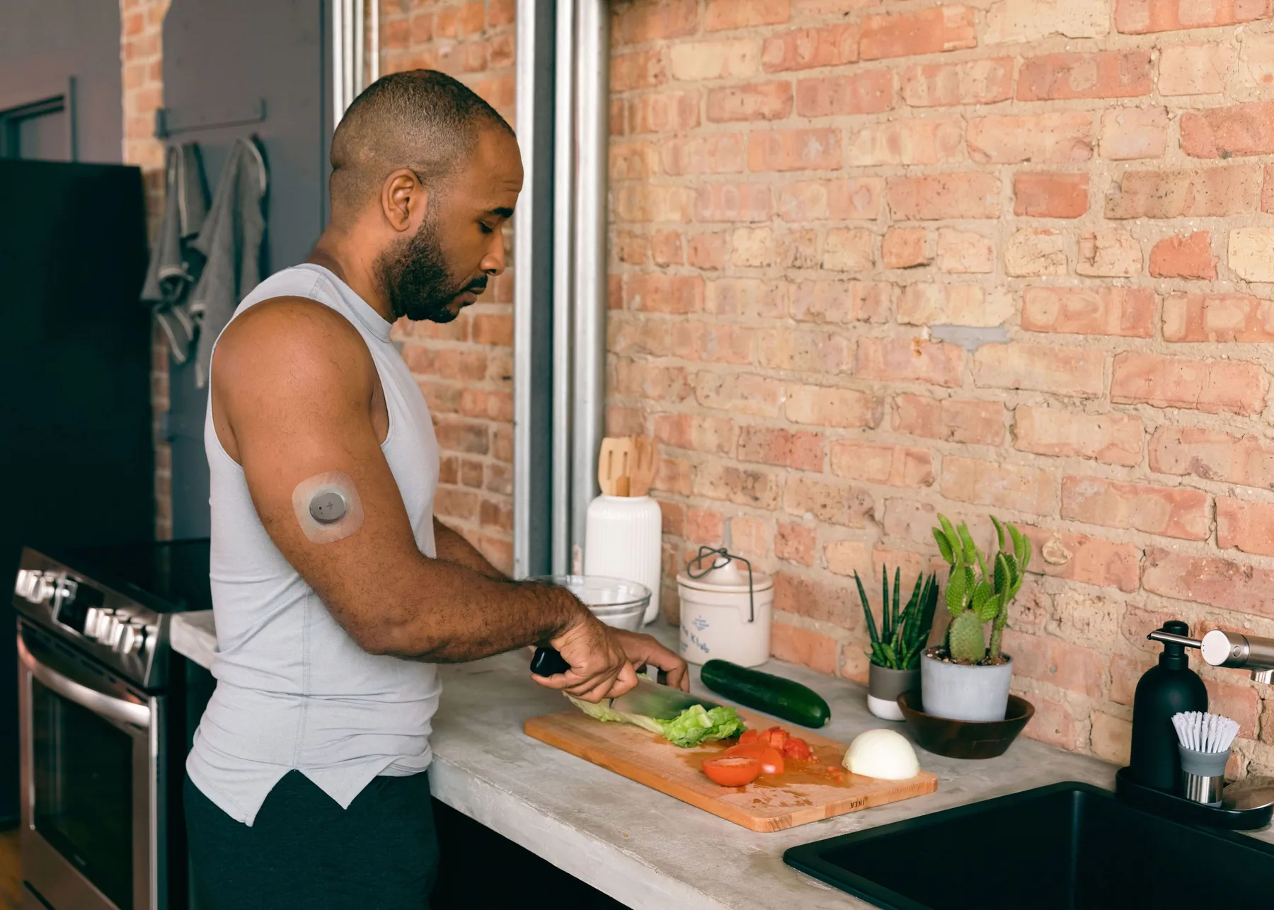 Man cutting vegetables wearing a Nutrisense CGM