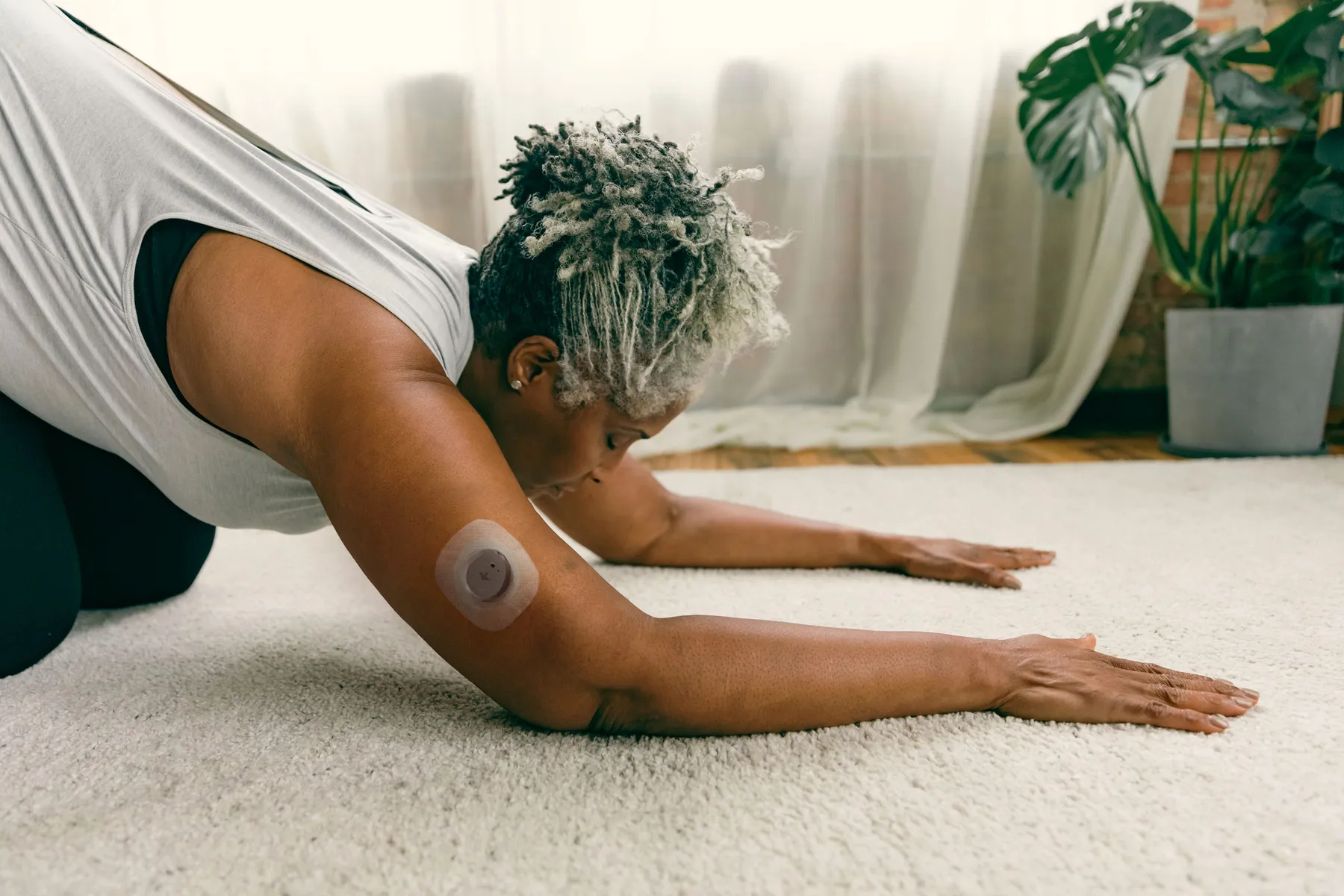 Older woman stretching with a Nutrisense CGM