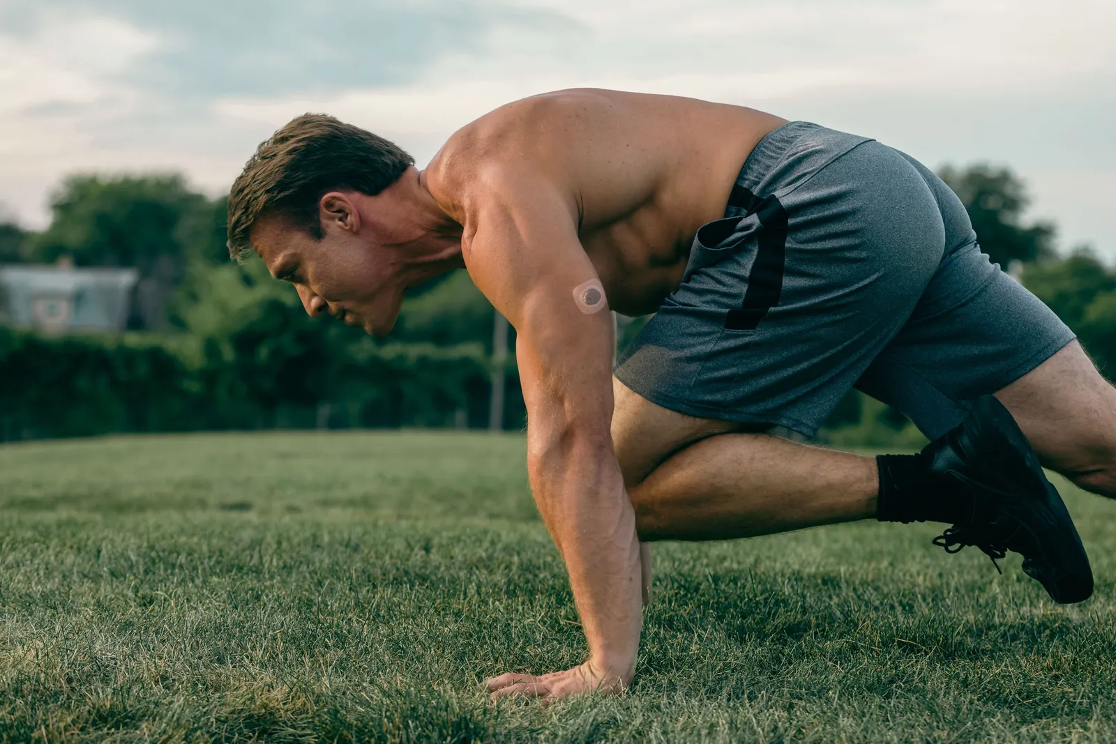 A Nutrisense member on grass positioned to start running.