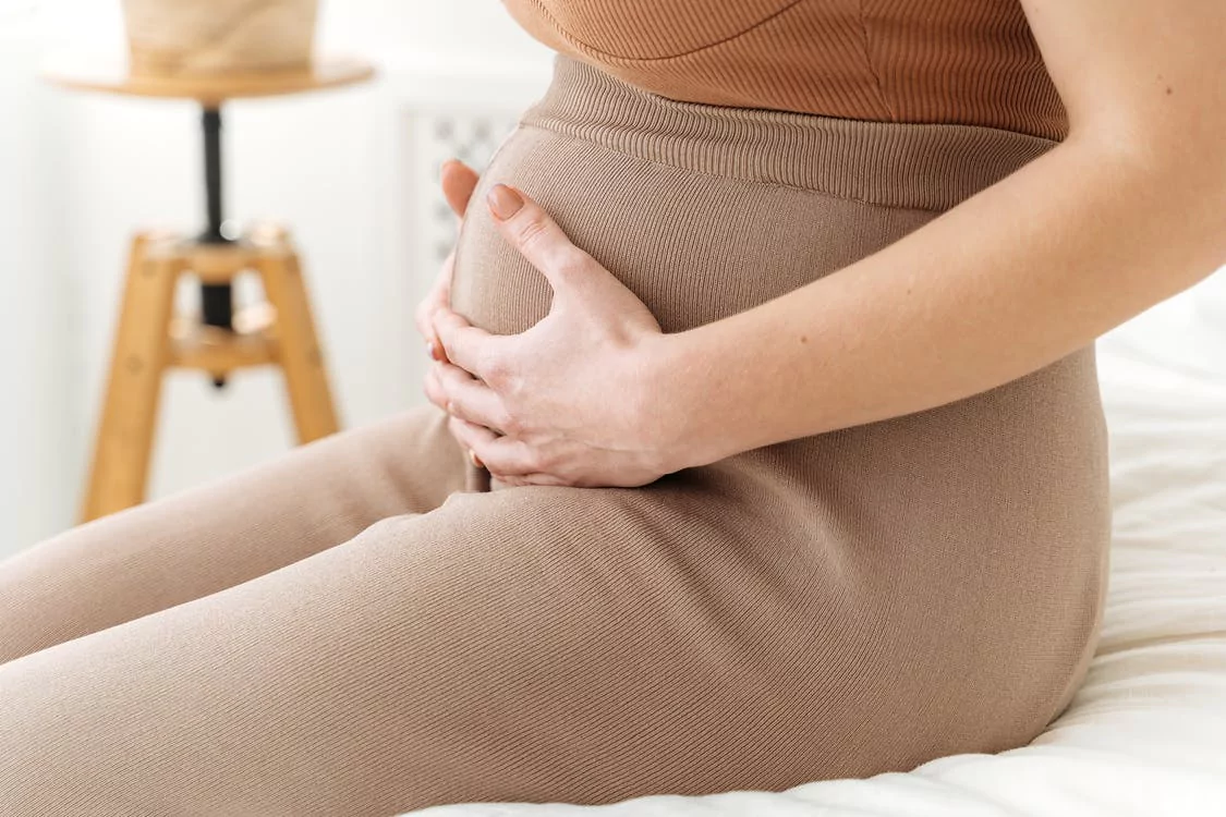 a pregnant woman holding her belly