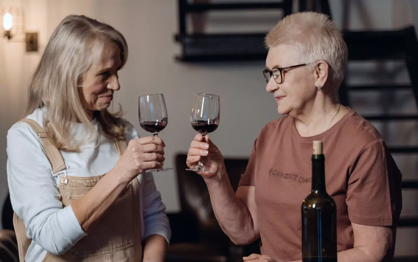 two  older people drinking wine