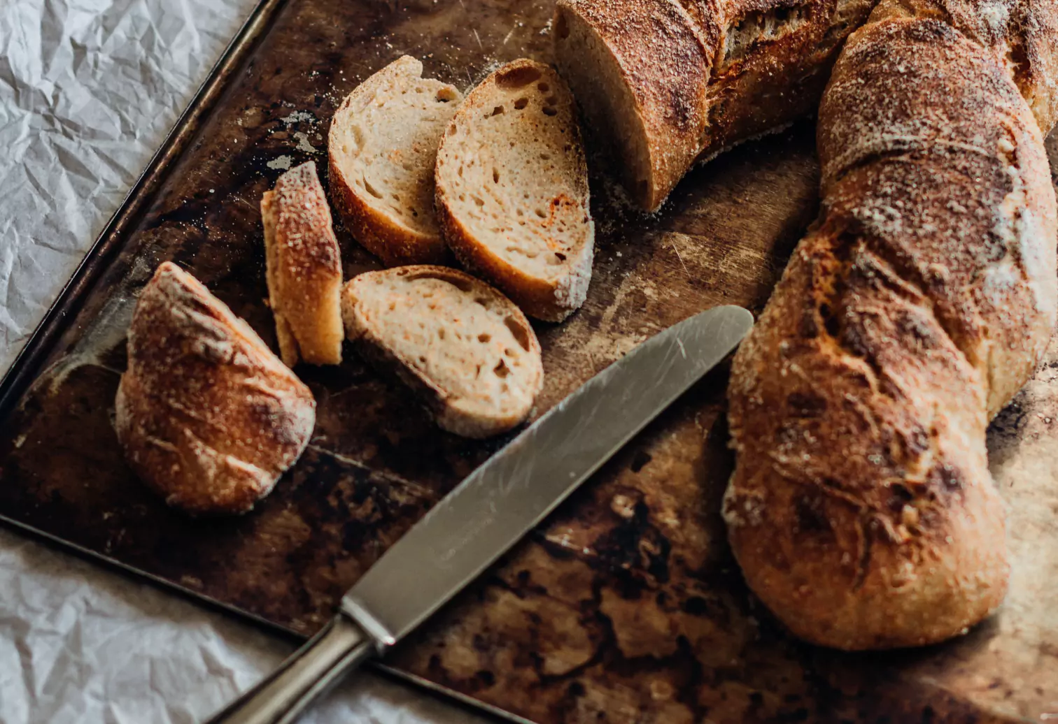 a loaf of bread, a few slices of bread and a knife