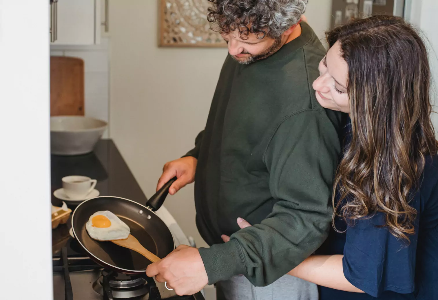 a couple cooking breakfast