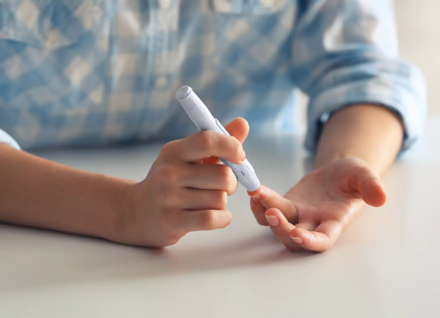 a person pricking finger to check blood sugar at home