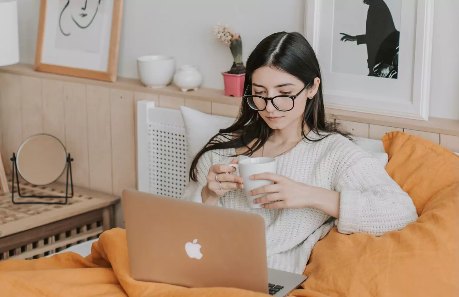 a person laying in bed looking at a laptop 