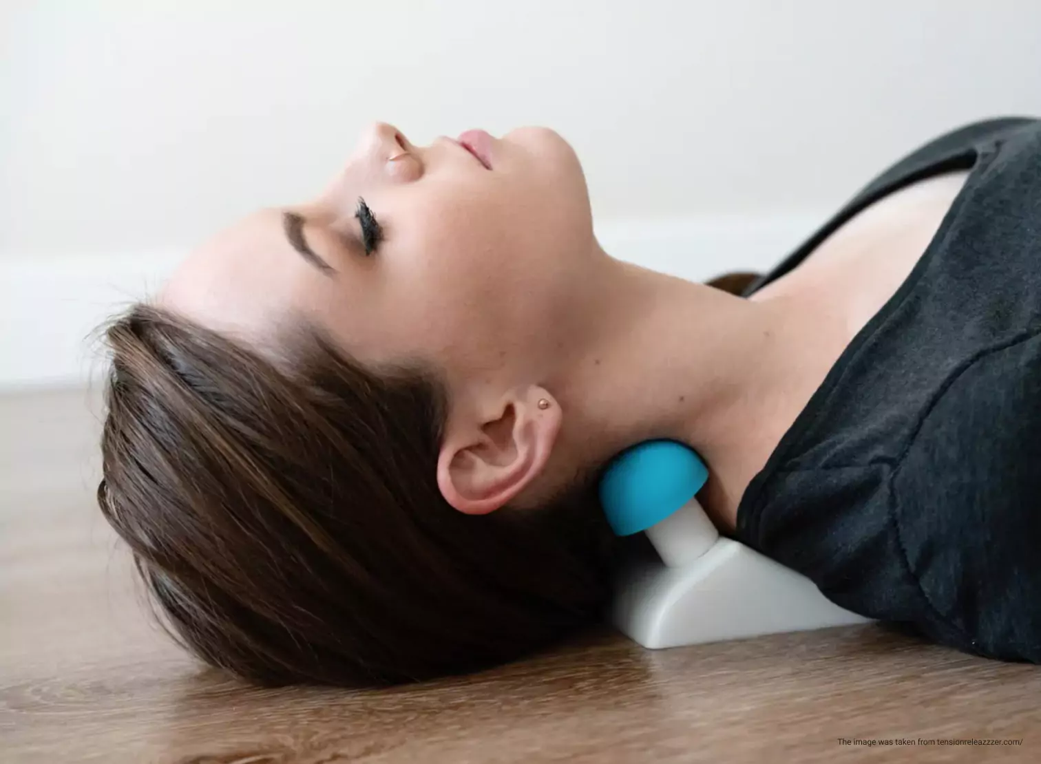 a person laying down on the floor using a self-massage device