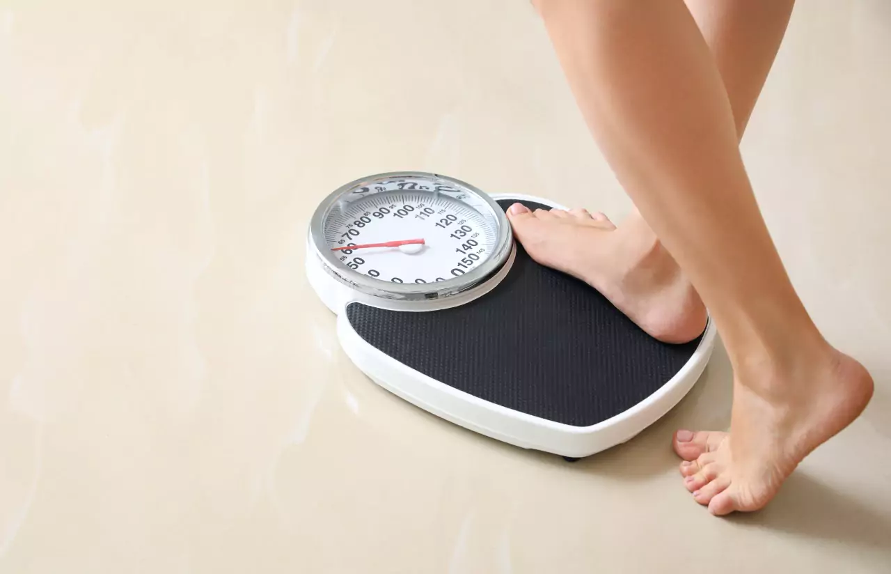 A woman's legs stepping on a weighing scale