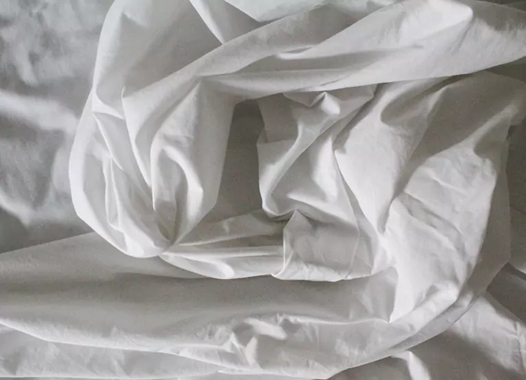 a pile of sheets in a bed