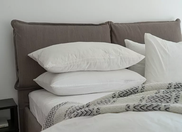 a stack of pillows in a bed