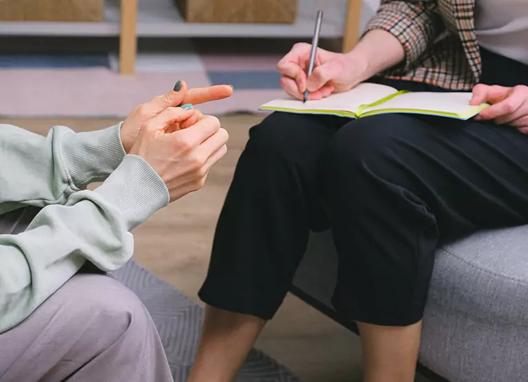 someone taking notes while another person talks