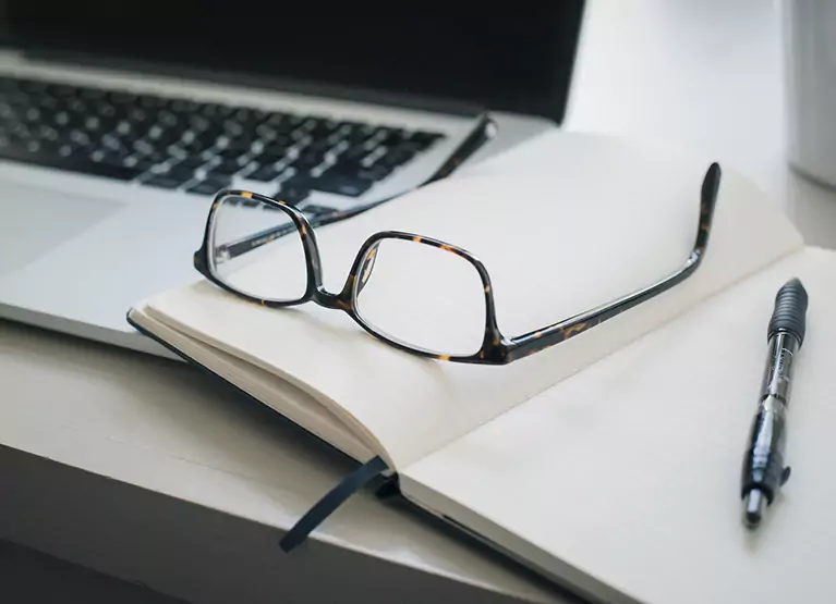 a pair of glasses on a notebook