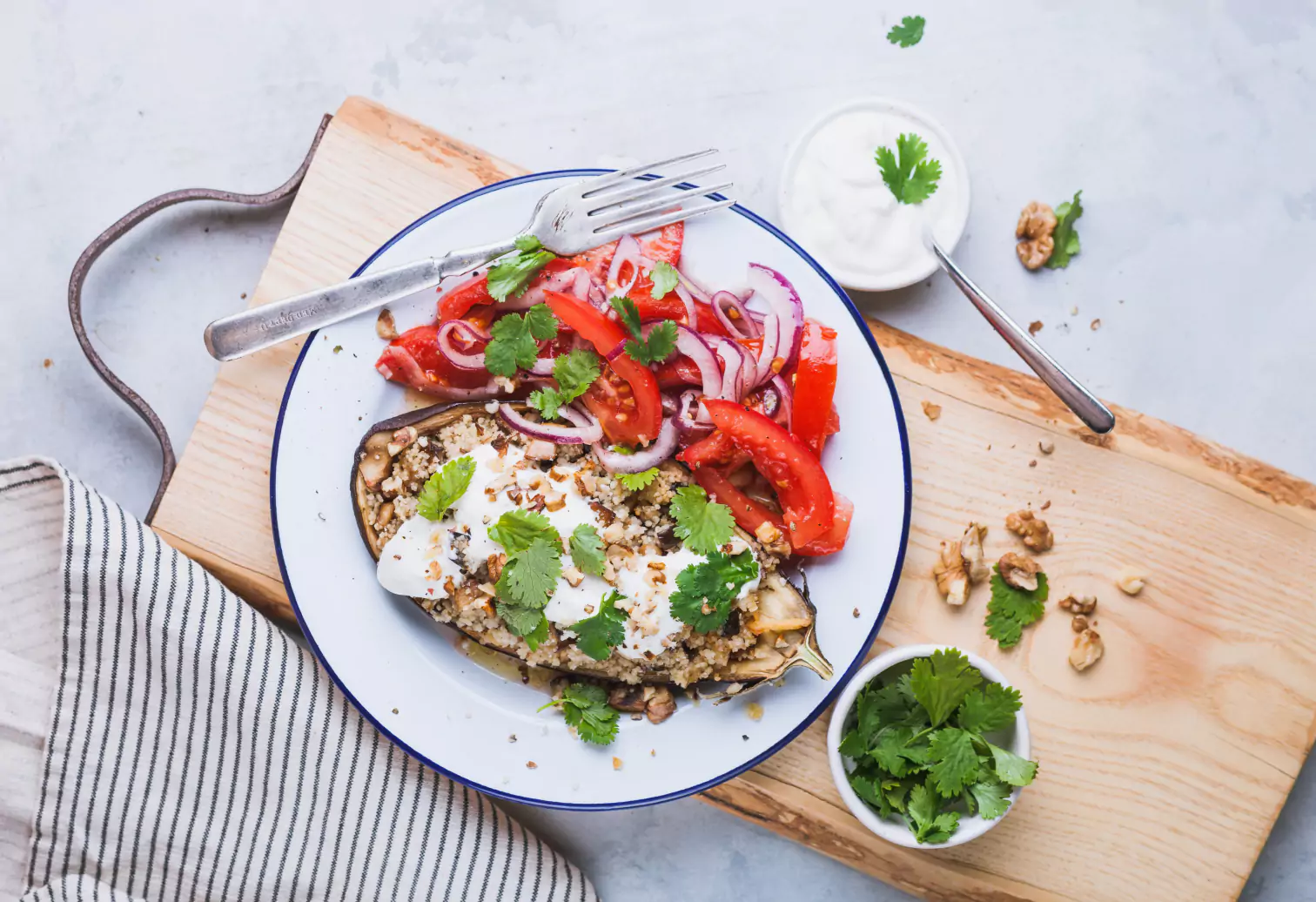 an aubergine, tomatoes, onion and parsley on a plate 