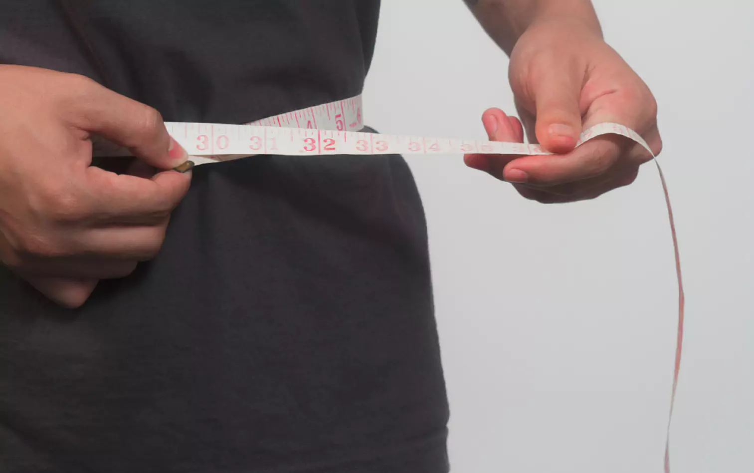 a person measuring their waist 