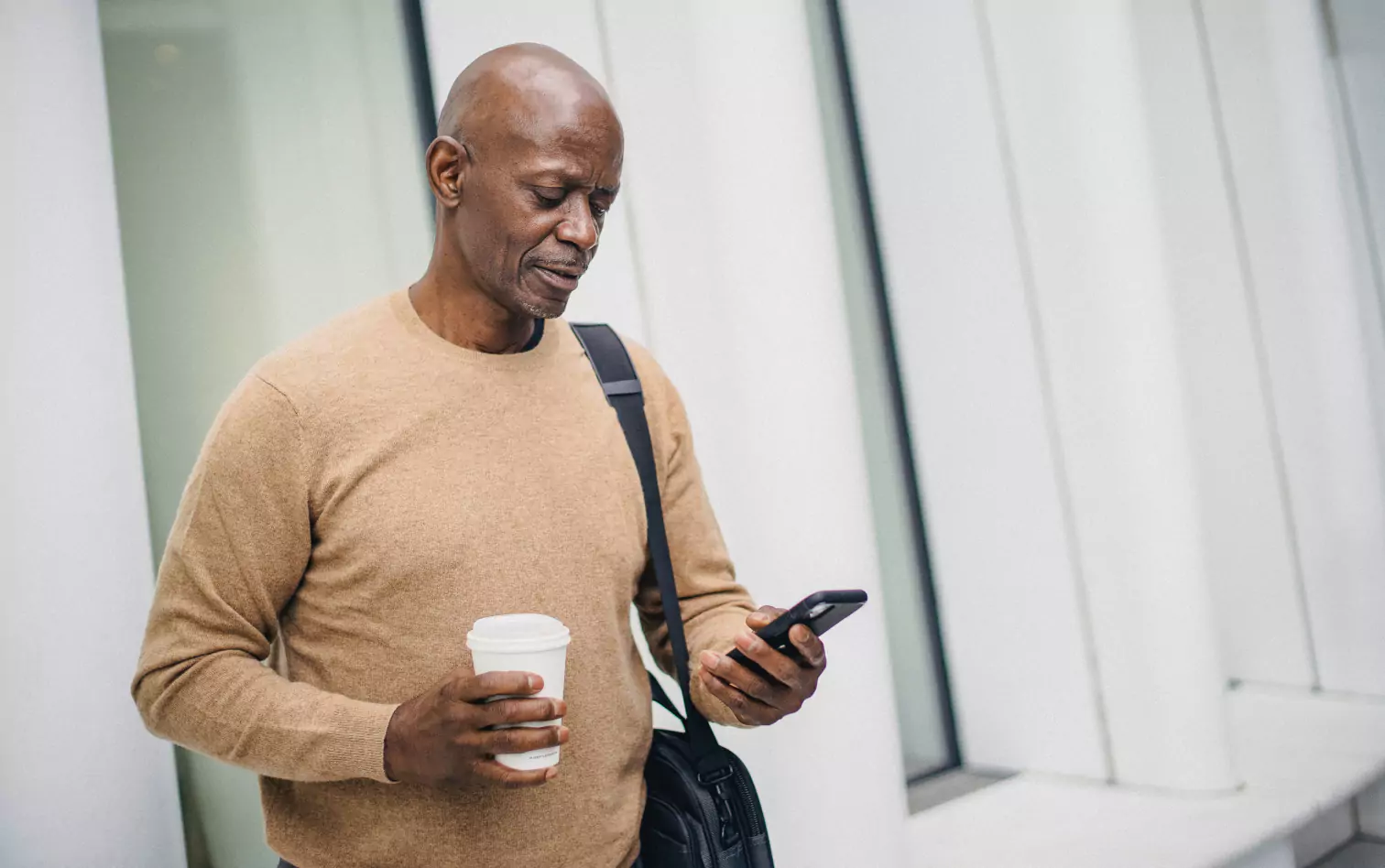 a person standing and looking at a phone