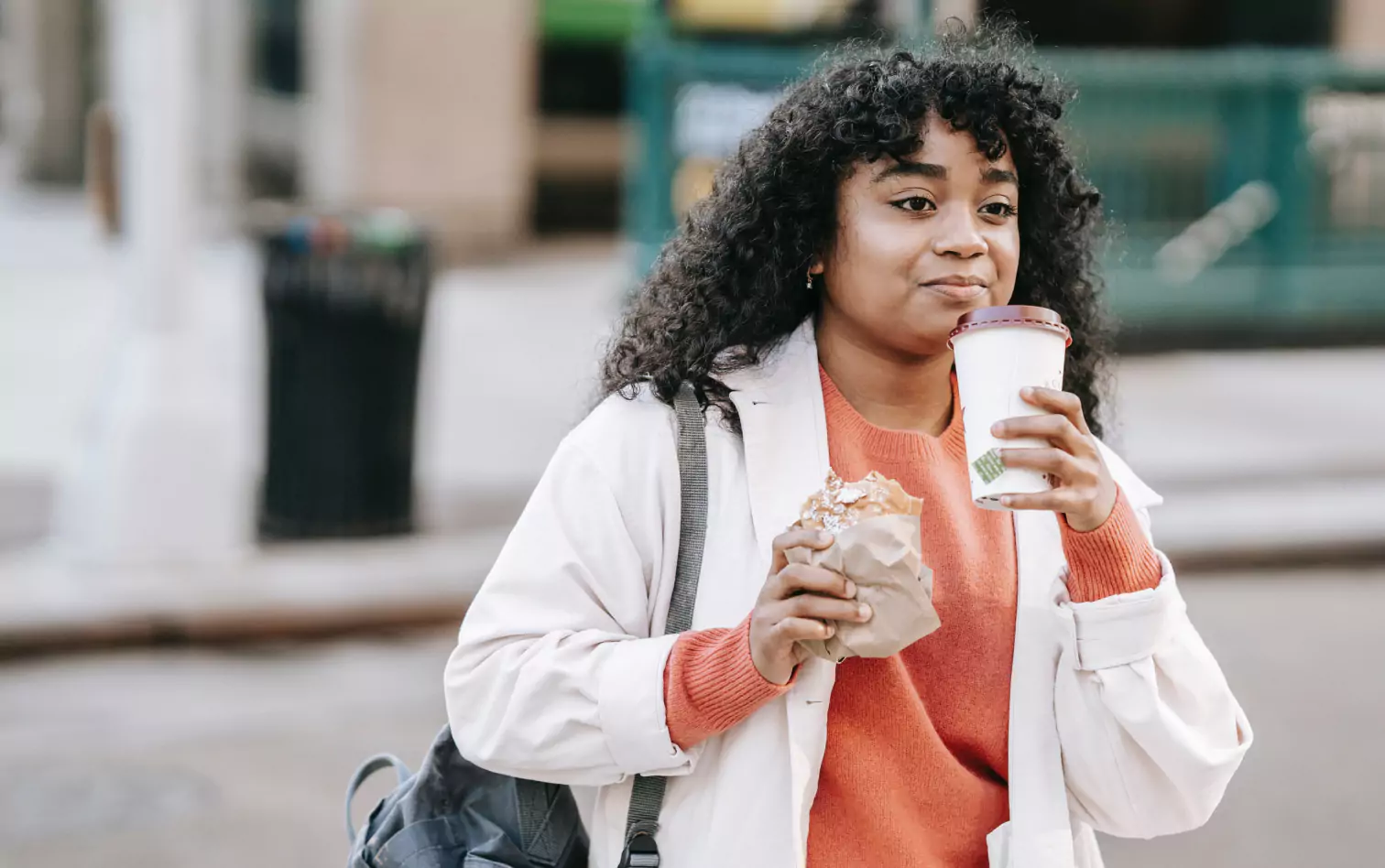 a person walking and drinking a coffee