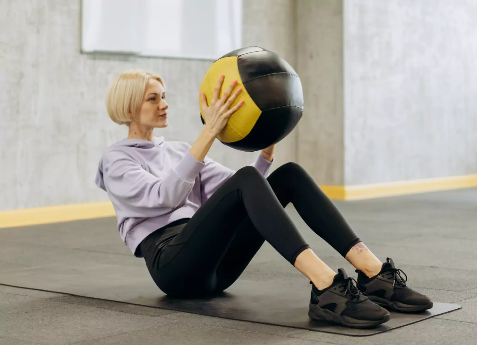 a person doing russian twists with weighted ball