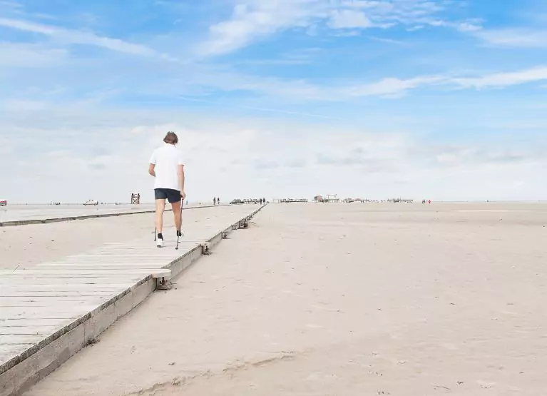 a person nordic walking on the beach