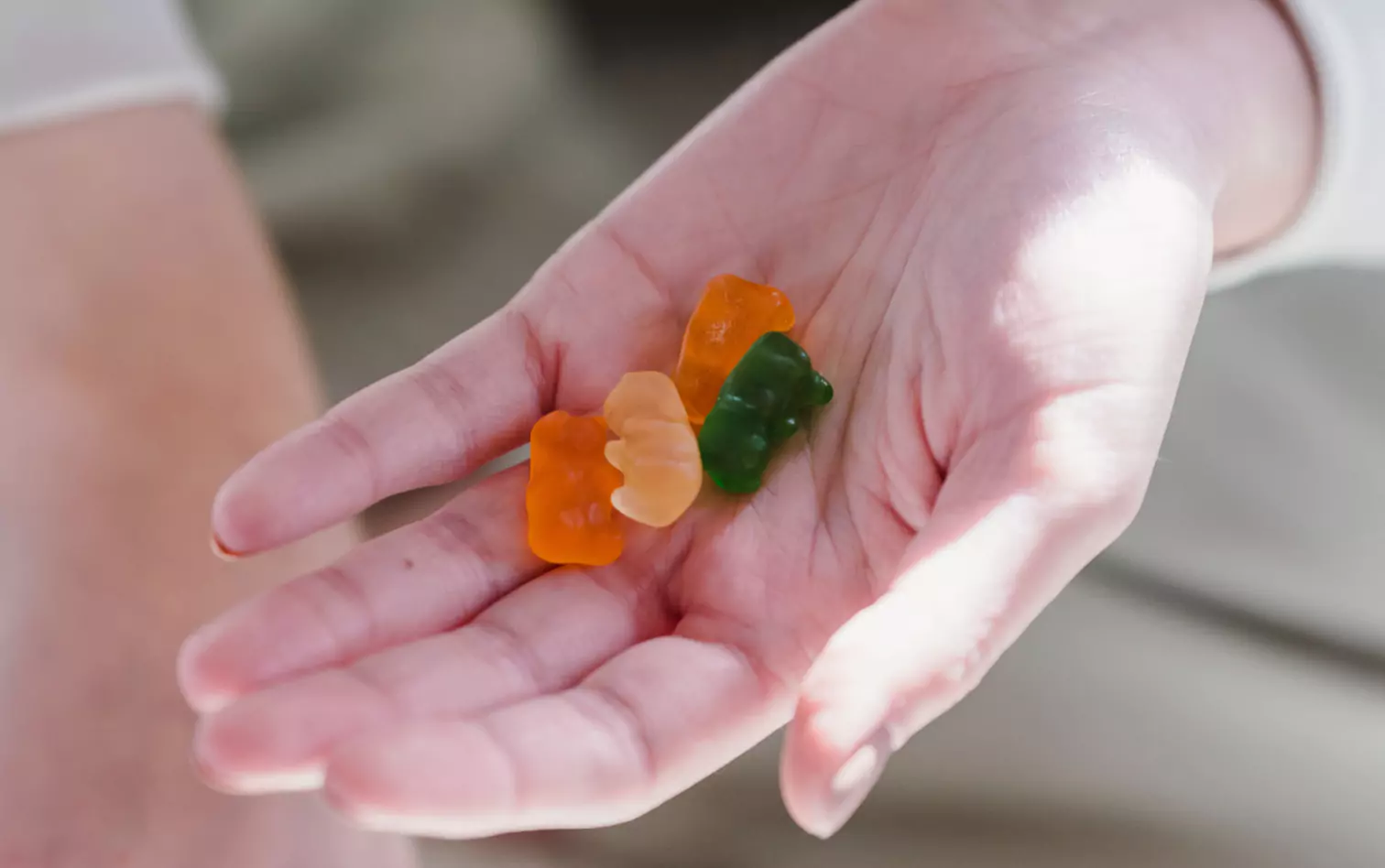 a person holding jelly bears on the palm of their hand