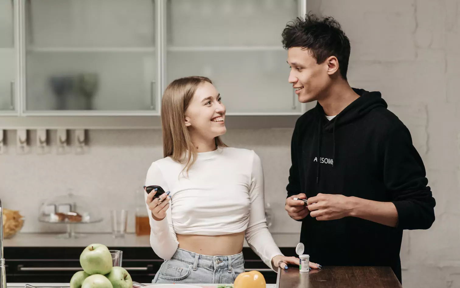 A couple in the kitchen with a glucometer