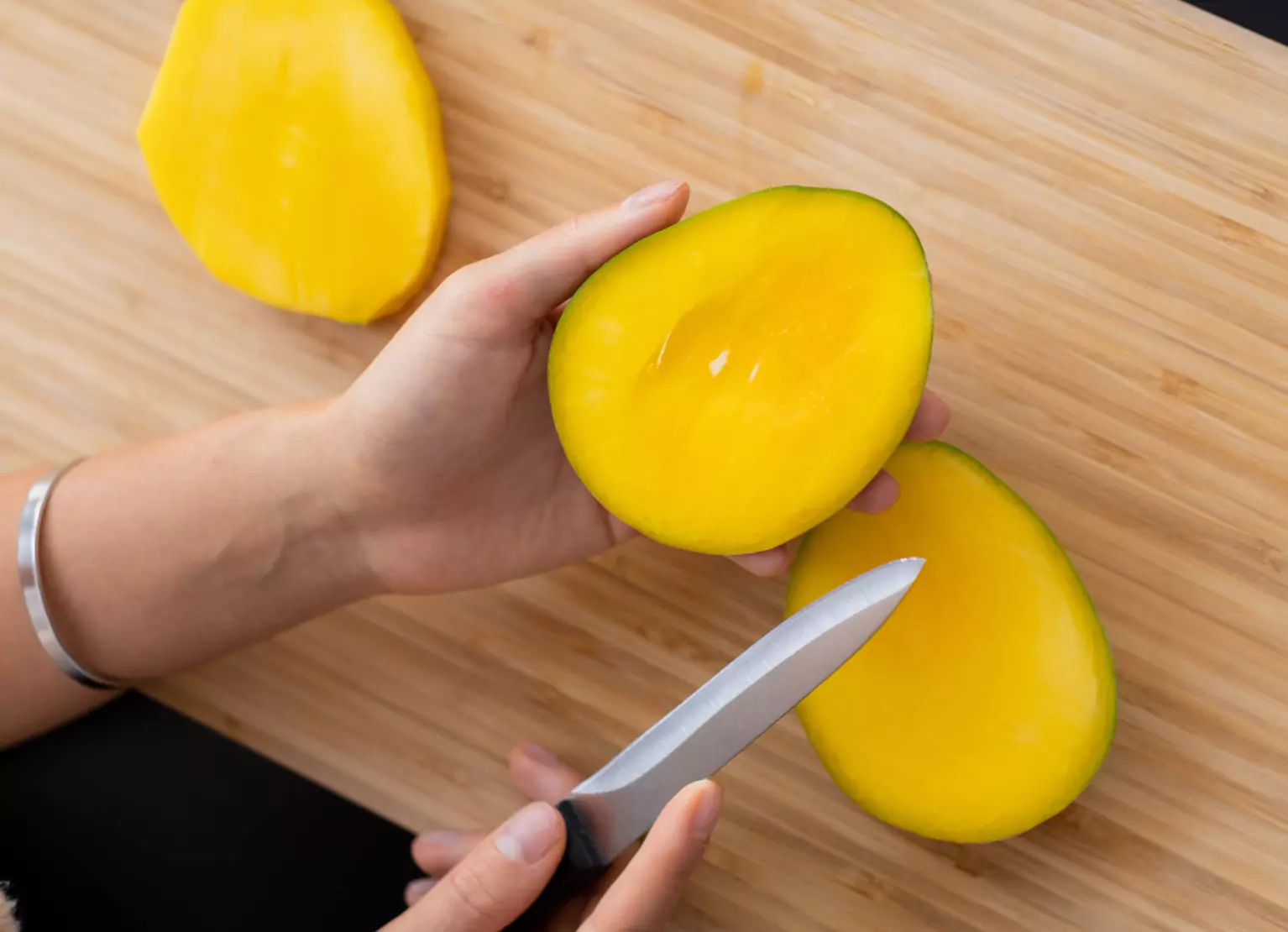 Person cutting mango