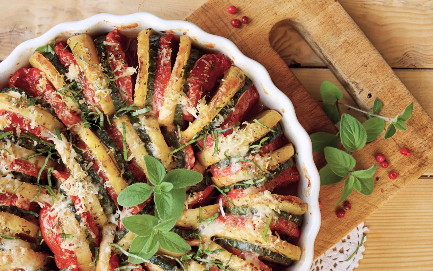 A dish of baked root vegetables with a sprig of sage s garnish