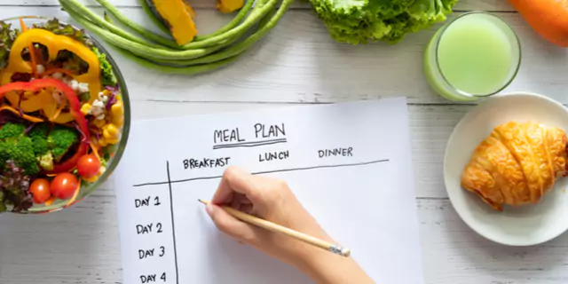 a person writing their meal plan 