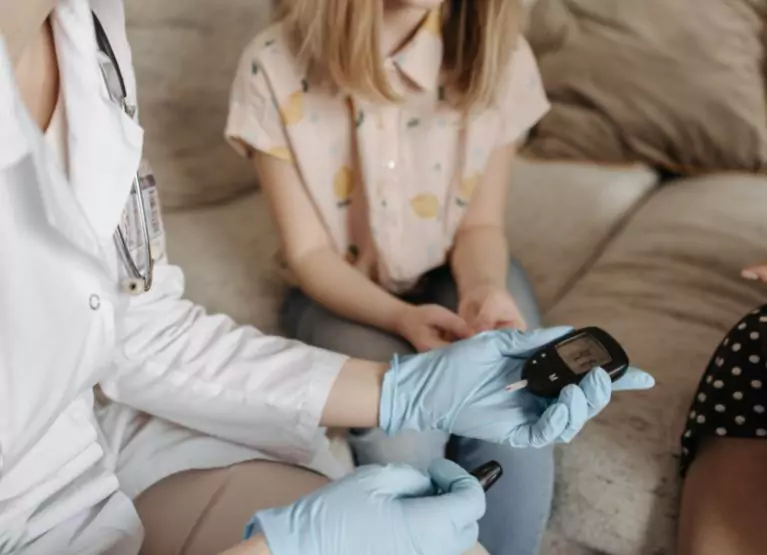 Doctor checking a patient's blood glucose with a finger prick