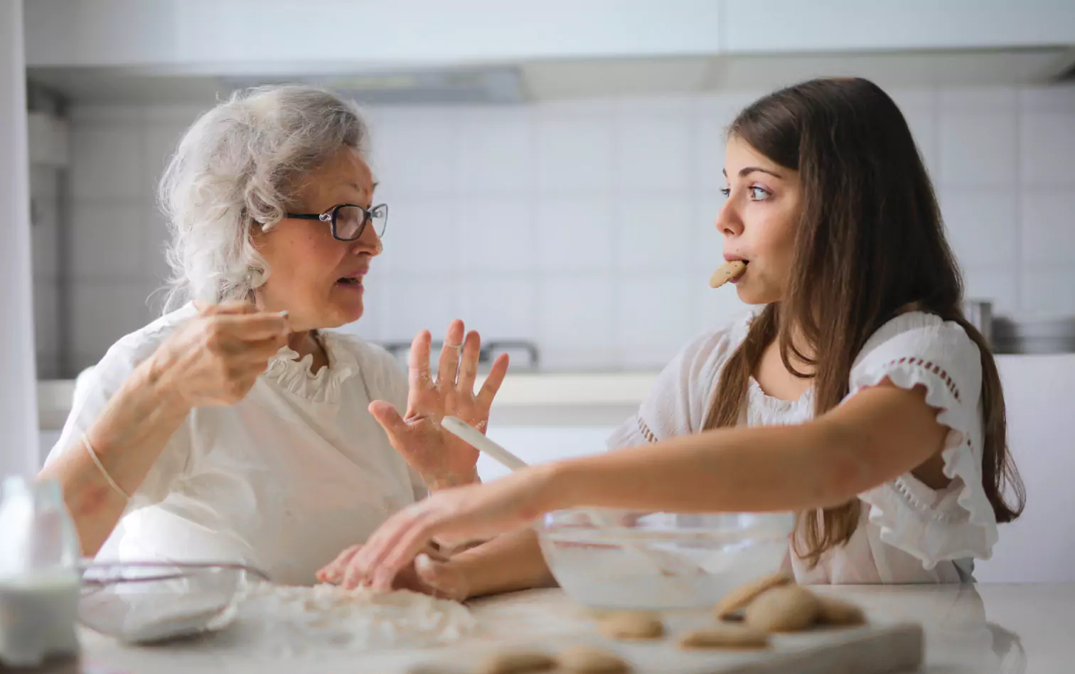 a couple of people making cookies and talking  