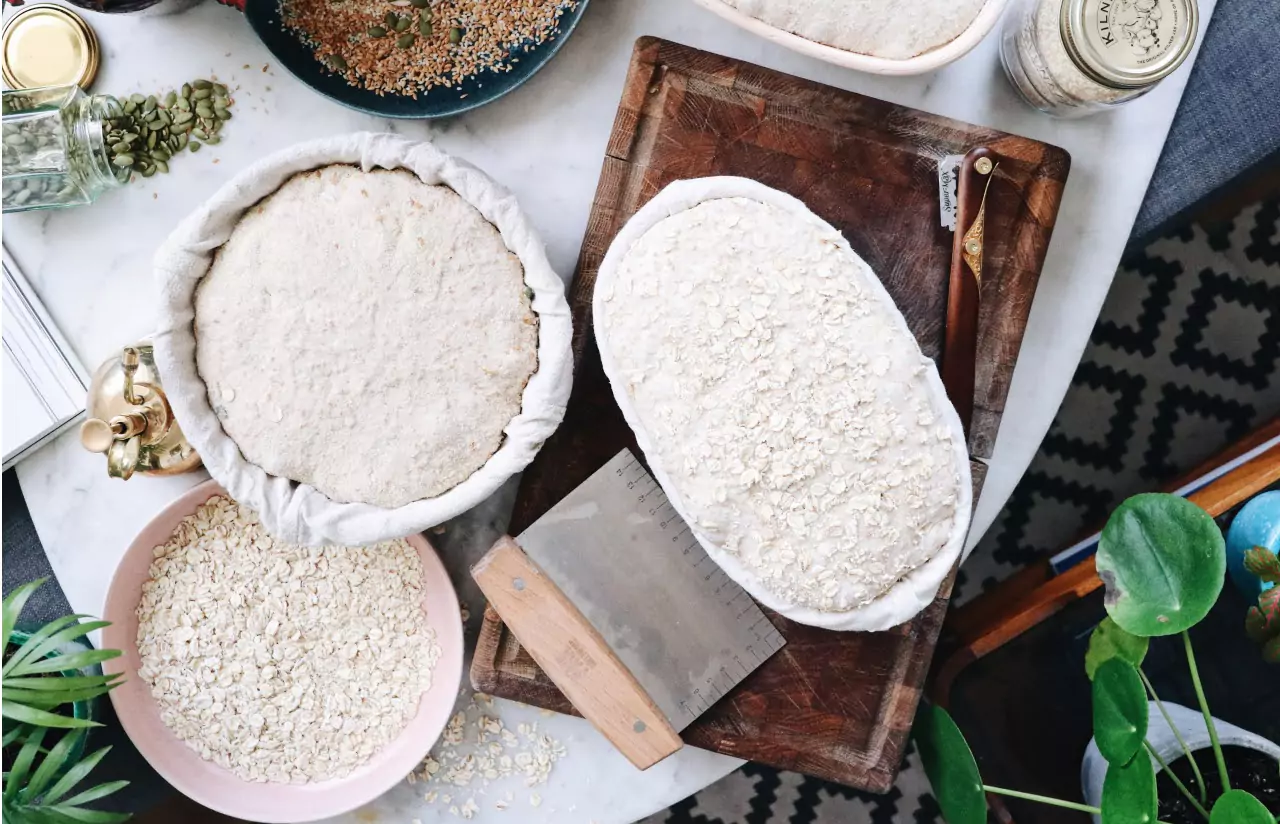 two baking pans with rolled oats bread before baking