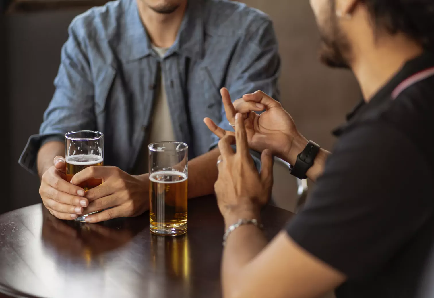 two people chatting with a beer