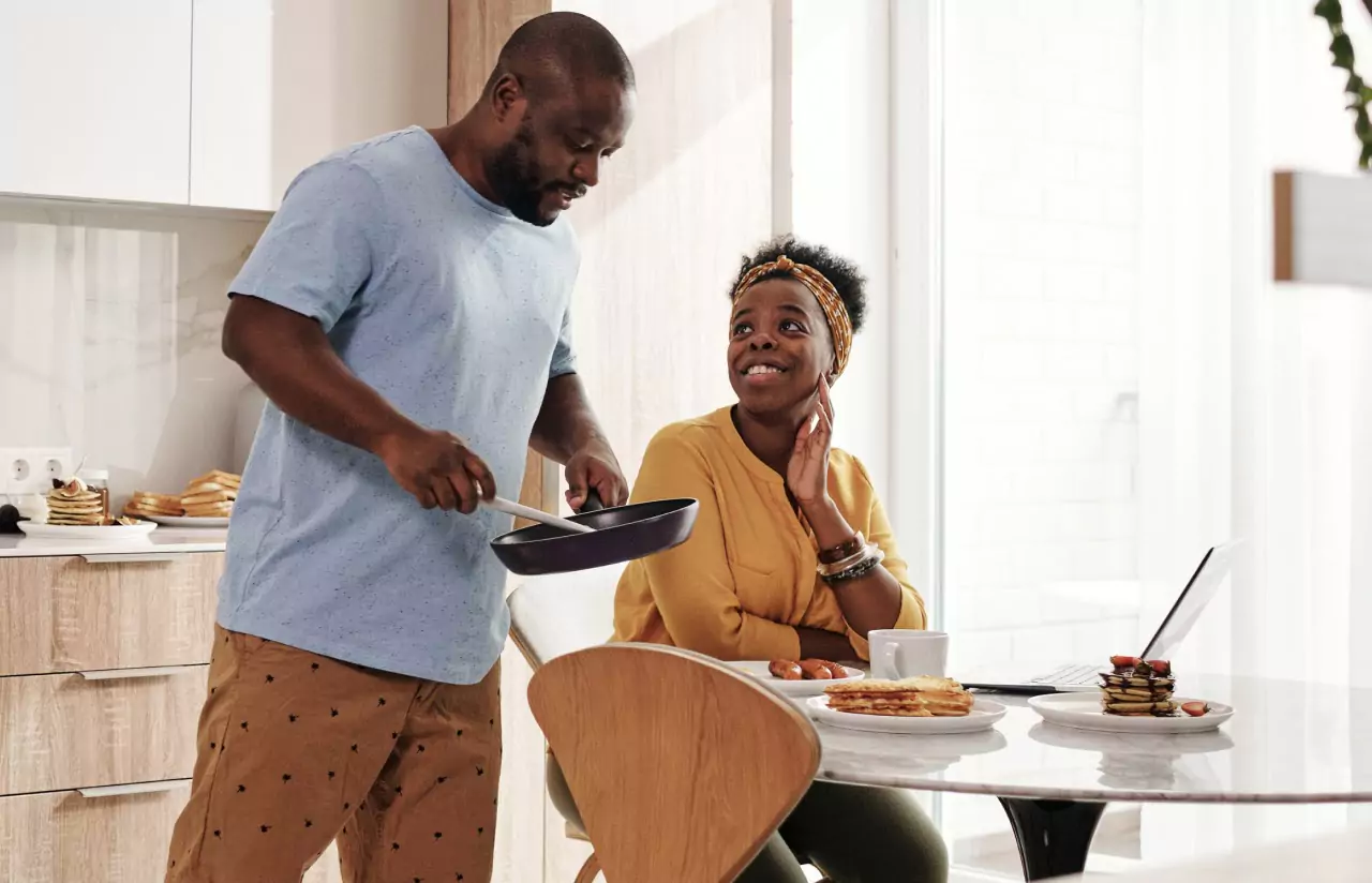 one person serving breakfast for another person in the kitchen 