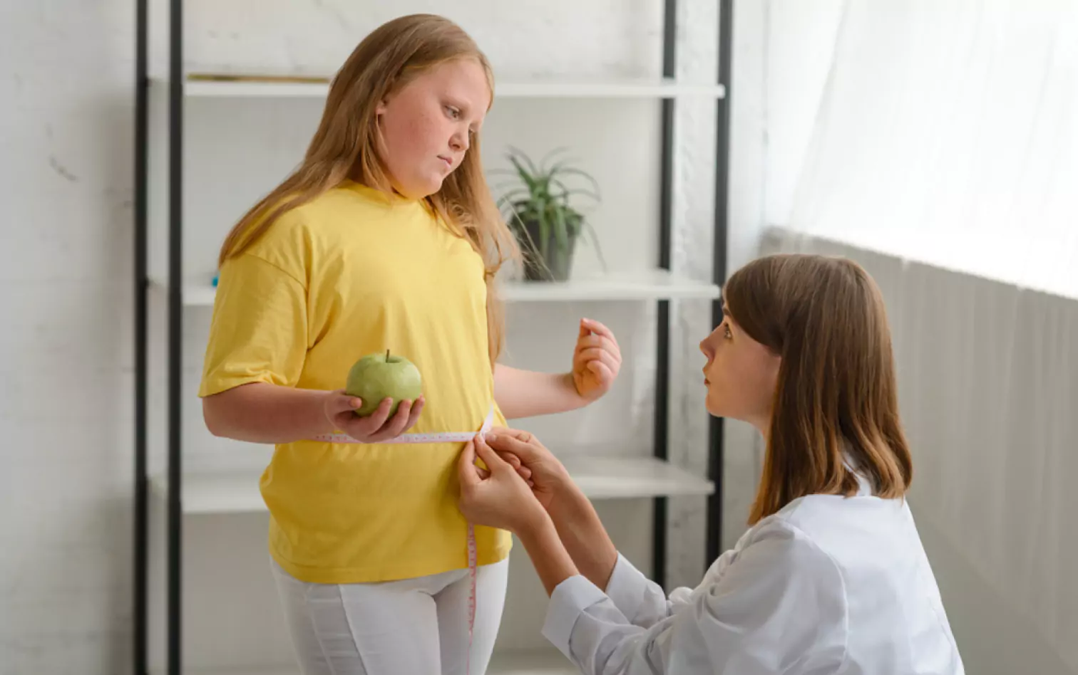 a doctor measuring child's waist 