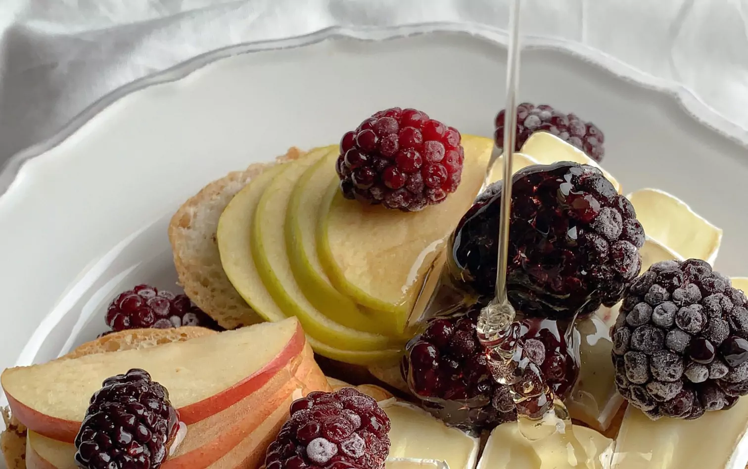 apples, berries and honey on a plate 