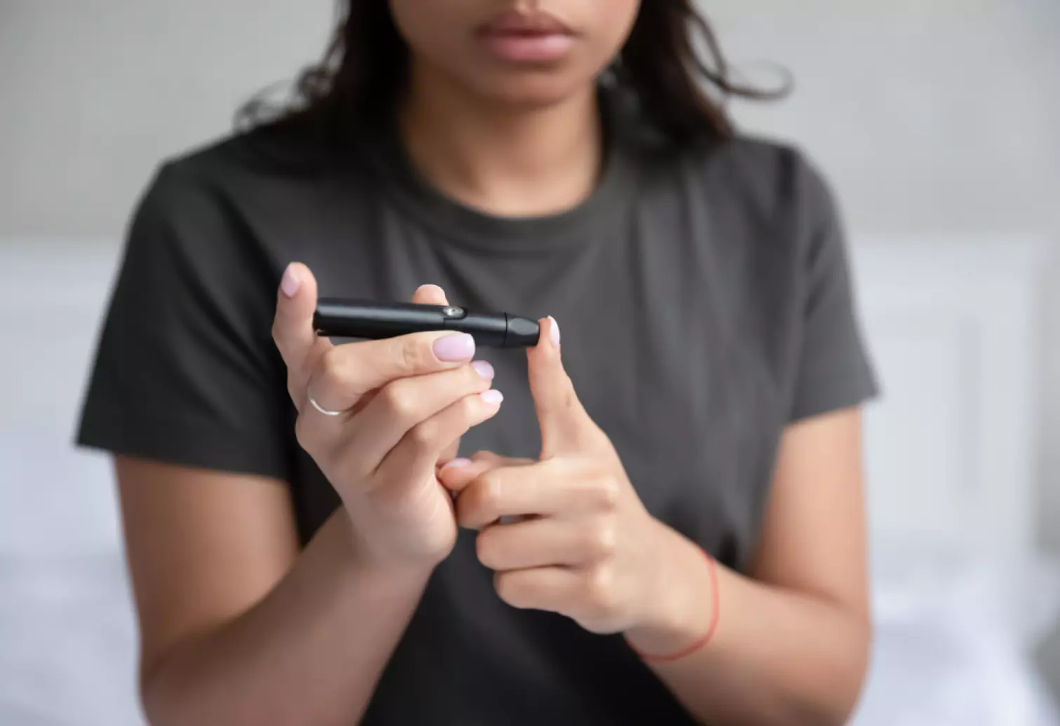 a person using finger prick method to test their glucose level