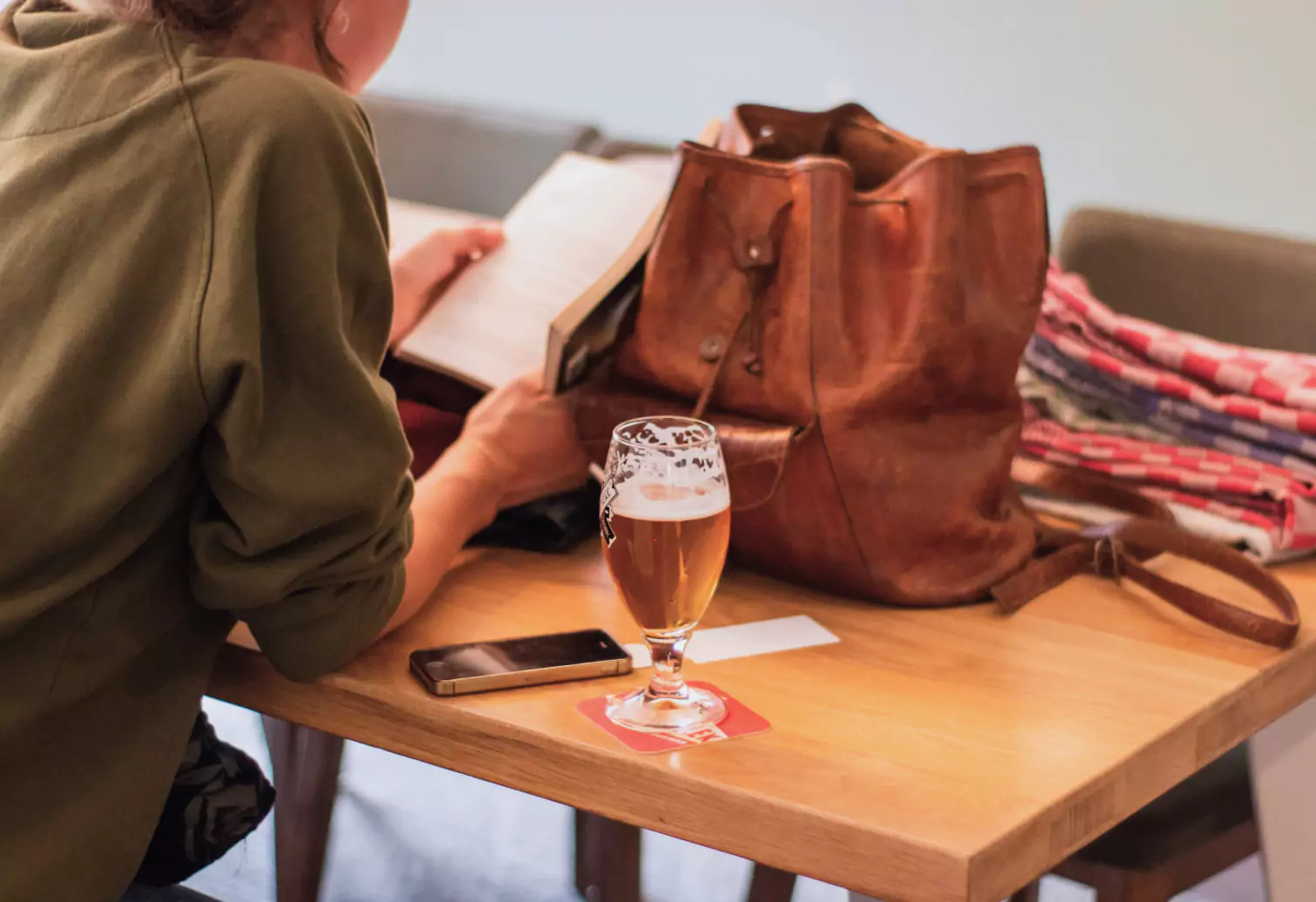 a girl reading and drinking beer