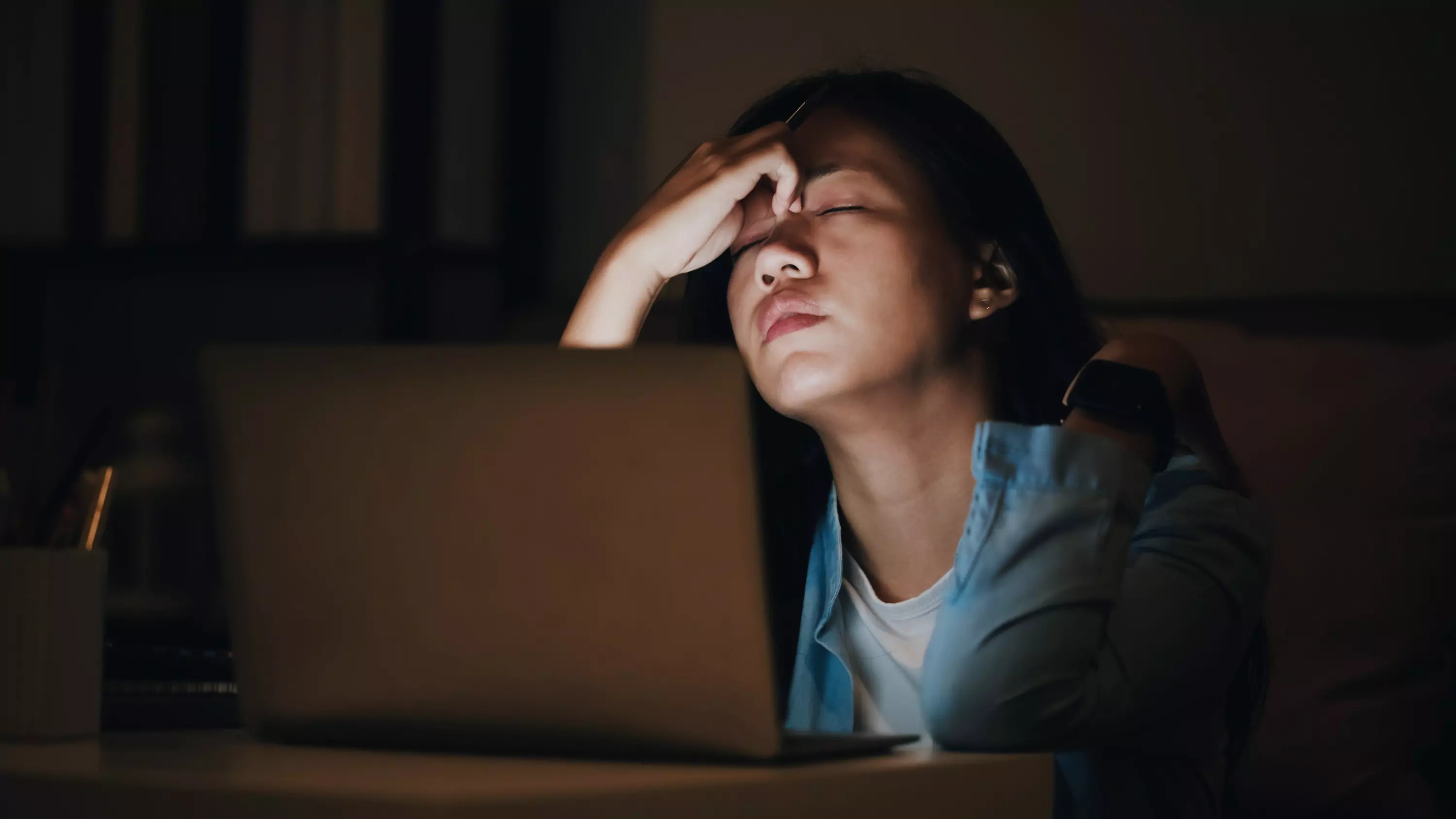 a person sitting at table looking tired 