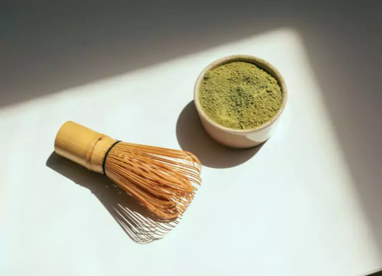 a bowl with matcha and a whisk