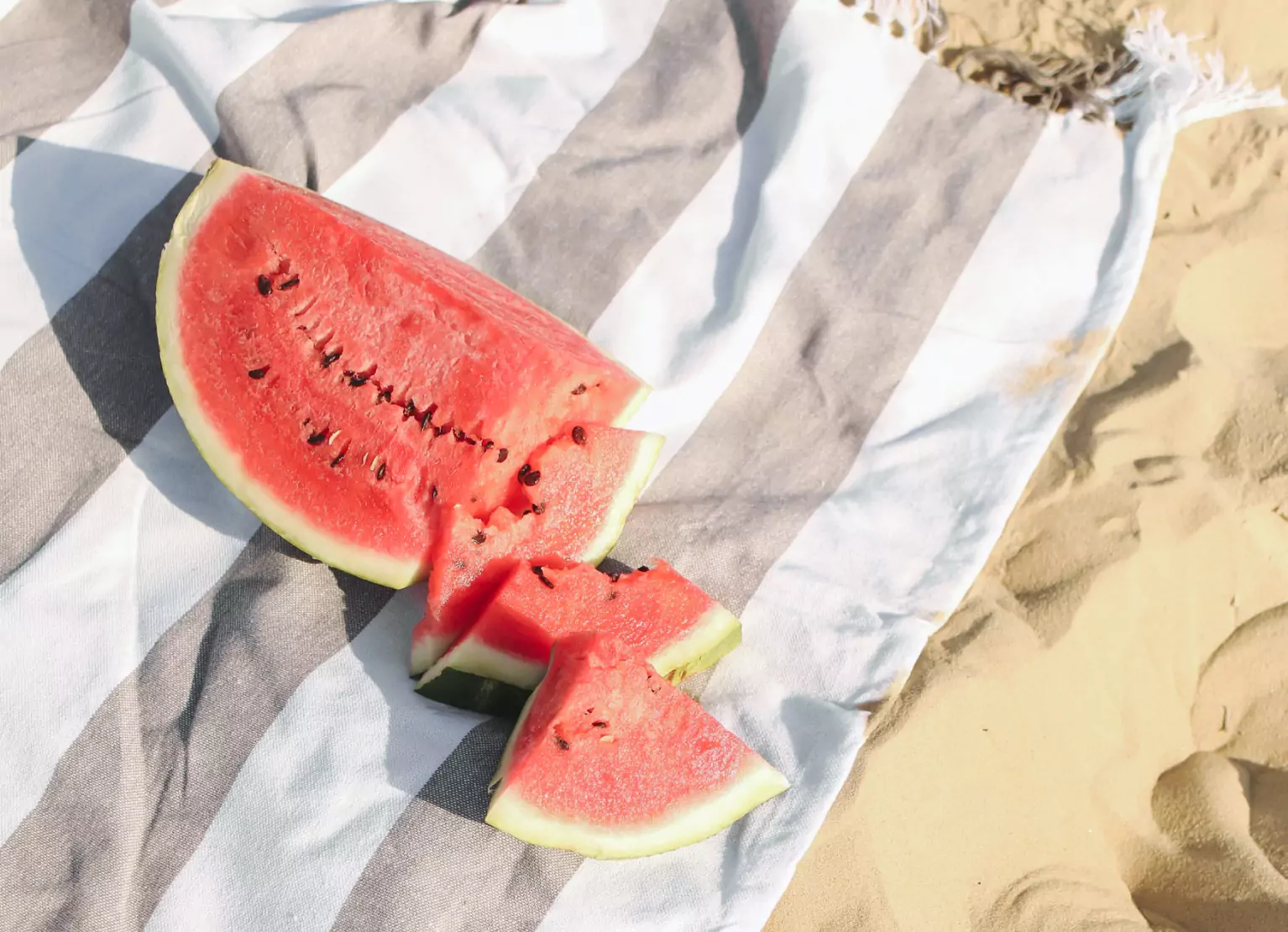 Cut up watermelon on a towel at the beach