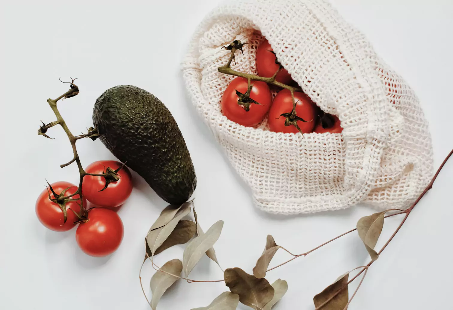 an avocado and a bag of tomatoes