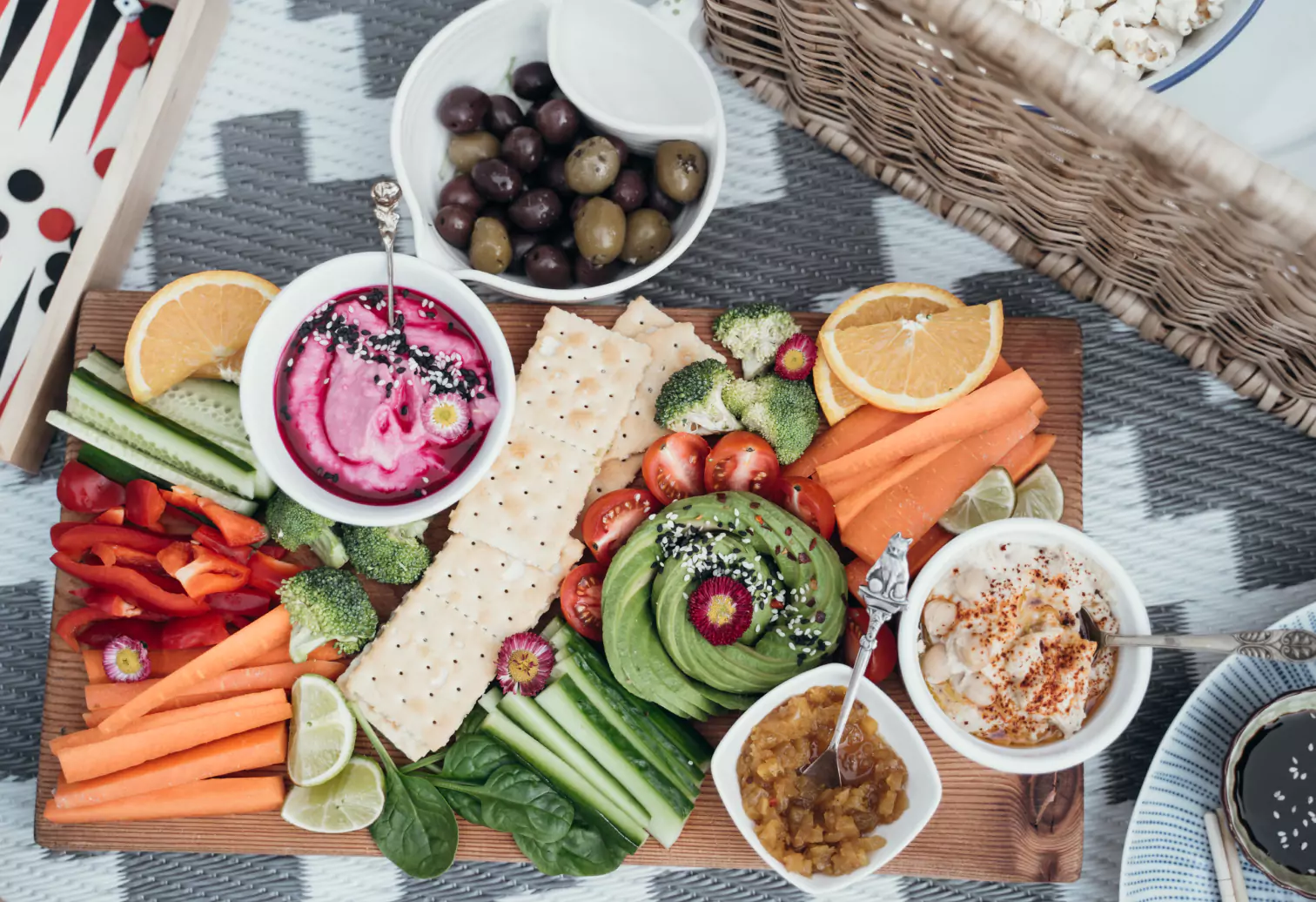 a board with dips, crackers and veggies