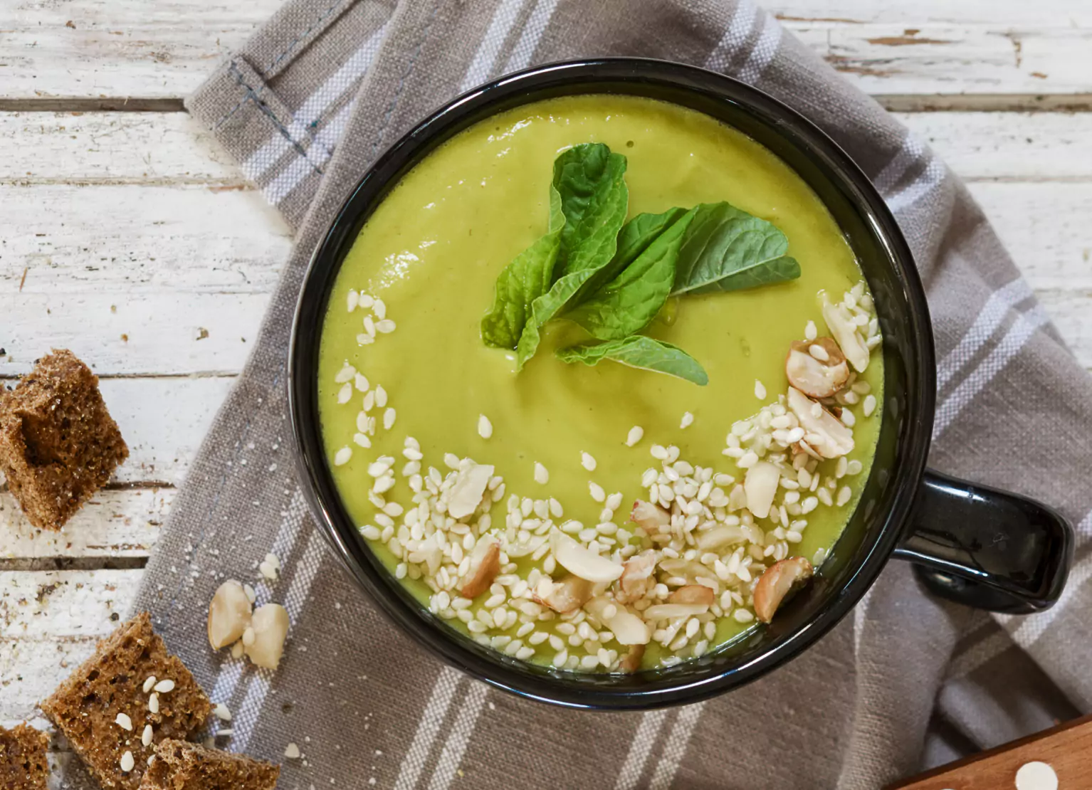 a bowl of avocado soup topped with seeds