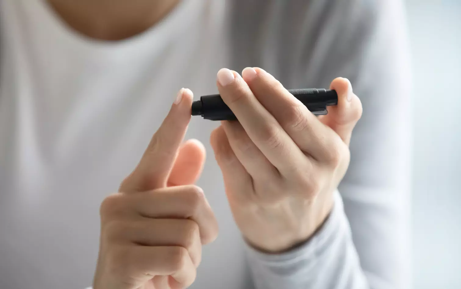 a person using finger prick method to test their glucose level