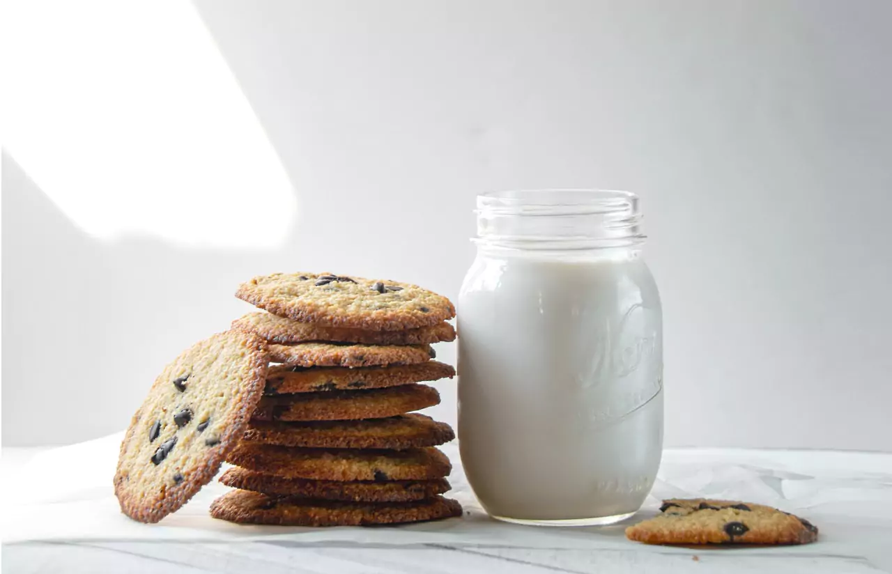 A jar of milk near a stack of cookies