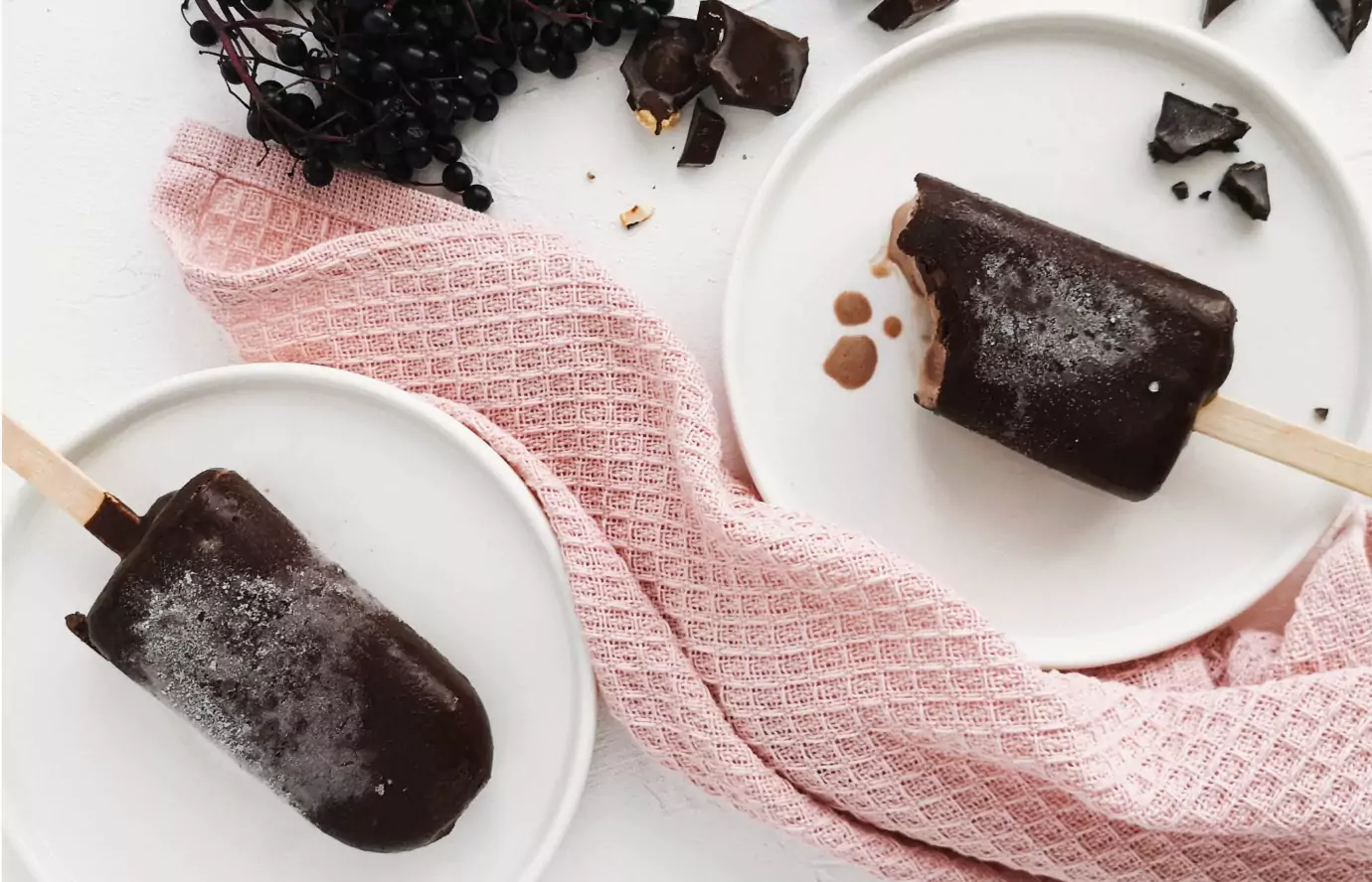 two sticks of chocolate ice-cream on plates 